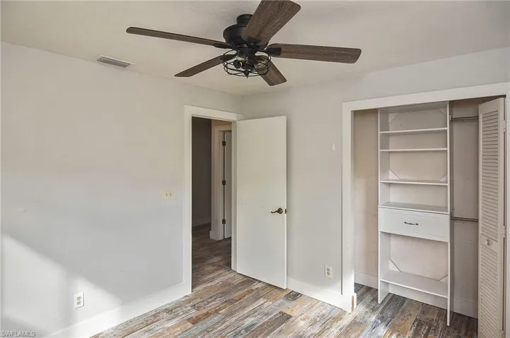 Unfurnished bedroom with wood-type flooring, ceiling fan, and a closet