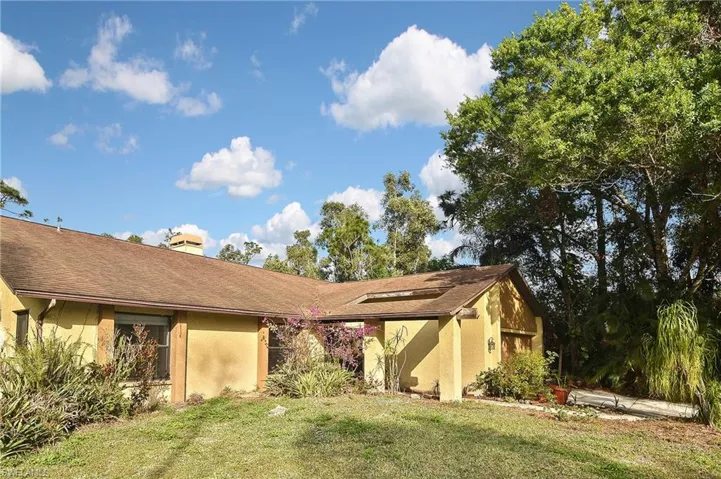Rear view of property with a yard