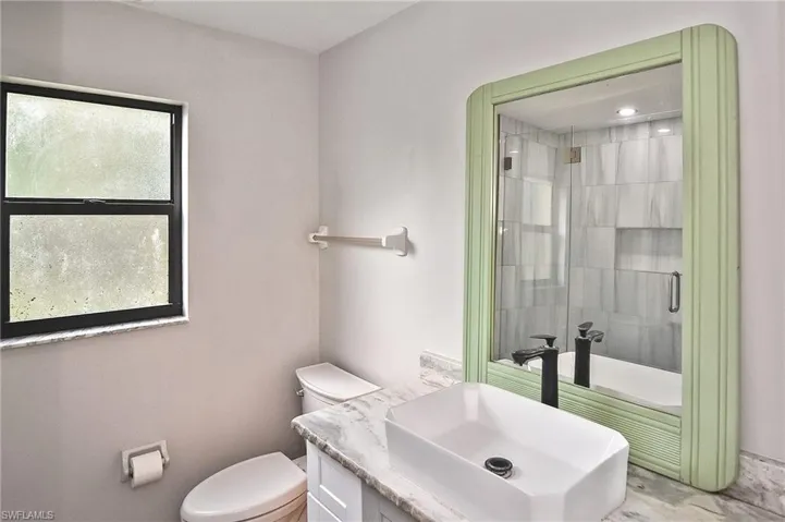 Bathroom with vanity, toilet, and a tile shower