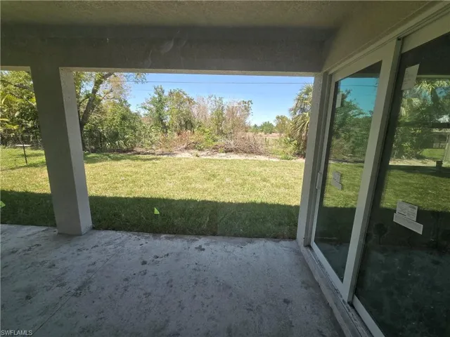 View of grassy yard featuring a patio area