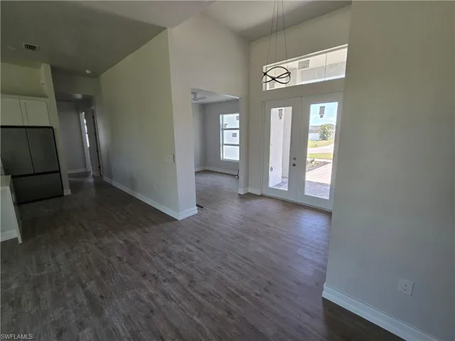Foyer with dark wood-style floors, a towering ceiling, and a ceiling fan