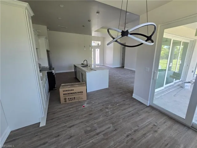 Kitchen with open floor plan, white cabinetry, healthy amount of natural light, and dark wood-style flooring