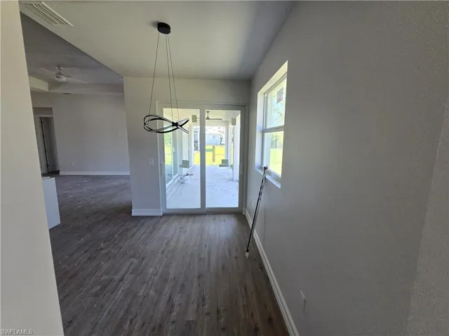 Unfurnished dining area with dark wood-style floors and ceiling fan