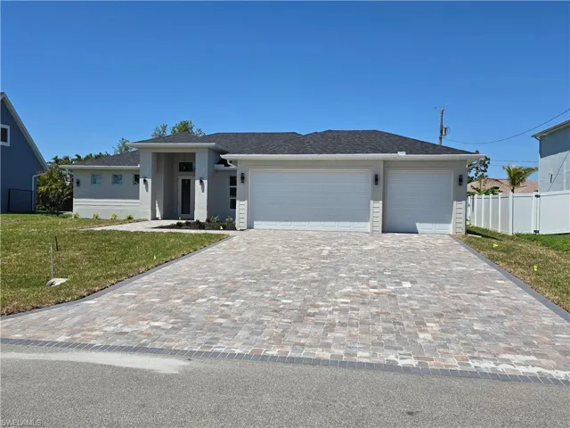 Prairie-style house with decorative driveway, a garage, stucco siding, and a shingled roof