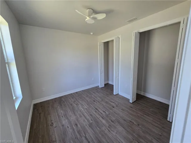 Unfurnished bedroom with dark wood-style floors