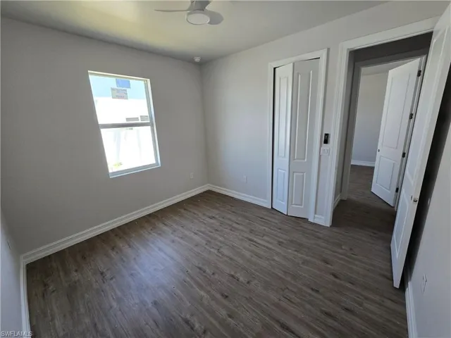 Unfurnished bedroom featuring dark wood-type flooring and a closet