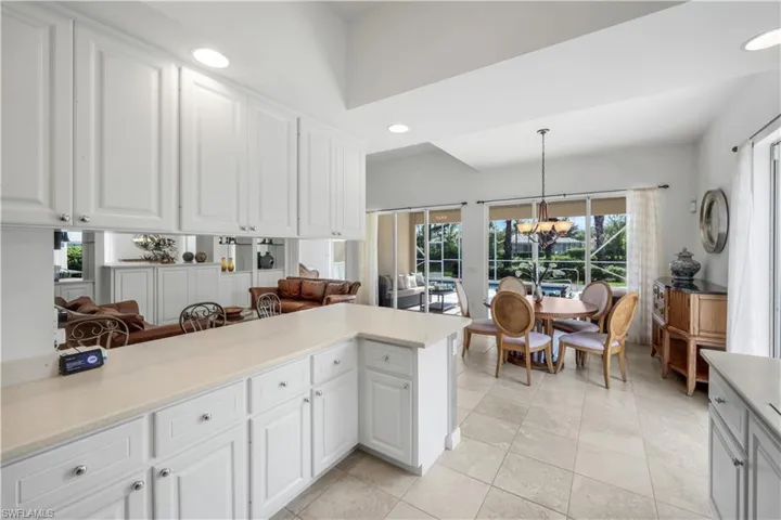 Kitchen featuring recessed lighting, white cabinets, hanging light fixtures, a chandelier, and light tile patterned floors