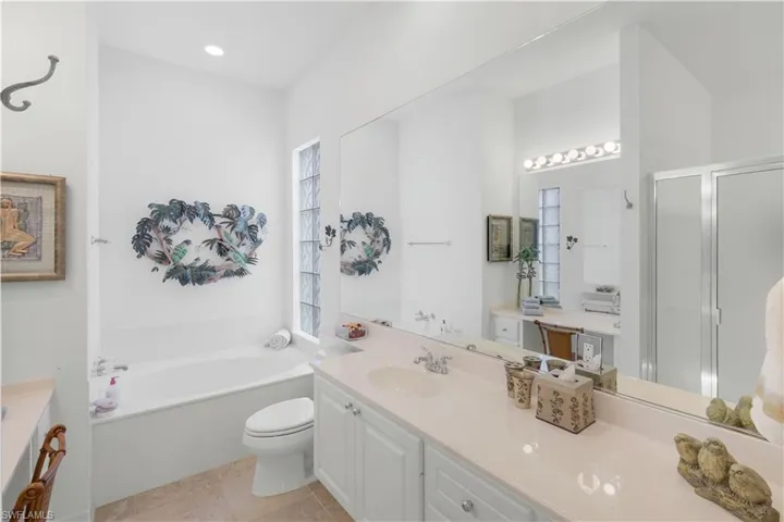 Bathroom with a garden tub, a stall shower, vanity, and light tile patterned floors
