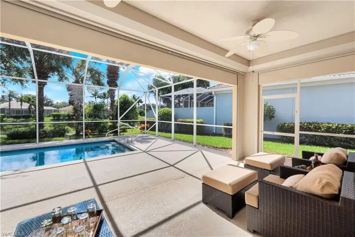 Outdoor pool with a sunroom, a patio, a ceiling fan, and a lanai
