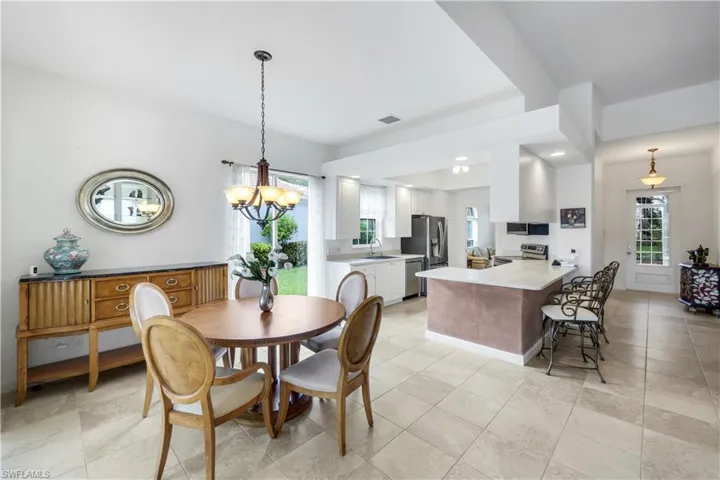 Dining space featuring a chandelier, light tile patterned floors, and recessed lighting