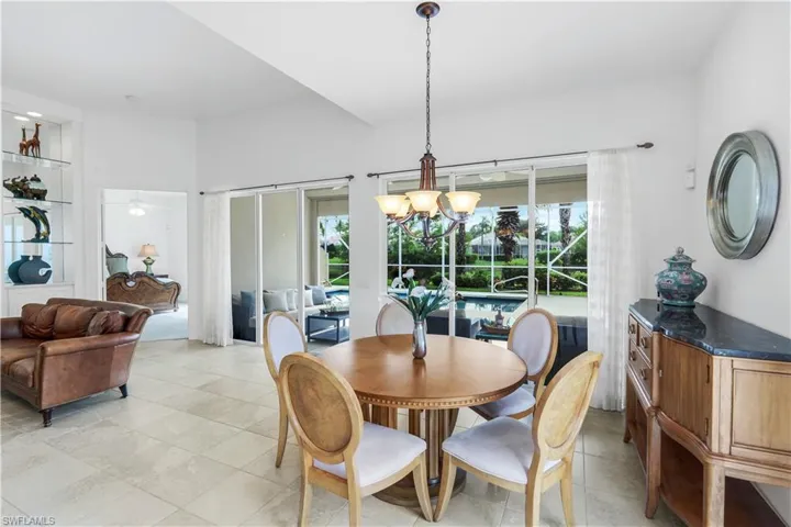 Dining space with a chandelier, light tile patterned flooring, and a sunroom