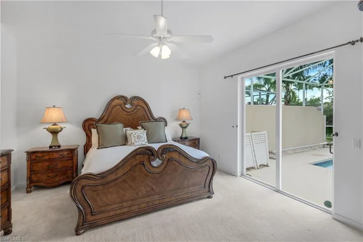 Bedroom featuring light carpet, a ceiling fan, and access to exterior