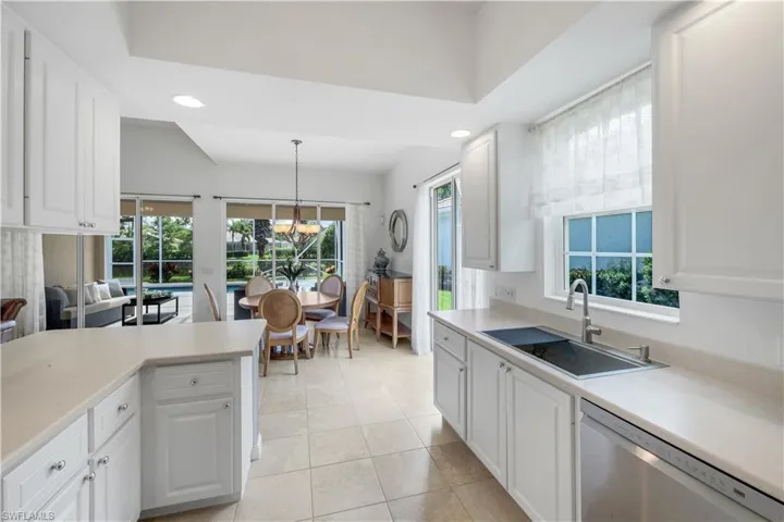 Kitchen featuring dishwasher, white cabinets, light countertops, recessed lighting, and pendant lighting