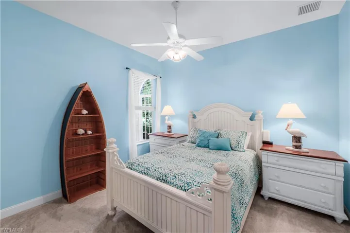 Bedroom with light colored carpet and a ceiling fan