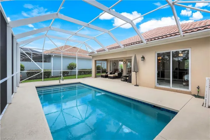 Swimming pool featuring a patio area, an outdoor hangout area, a sunroom, and glass enclosure