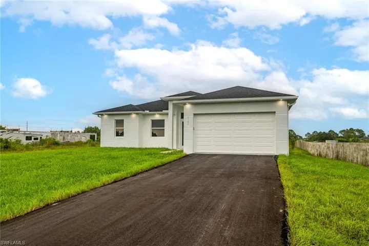 View of front of property with a front yard and a garage