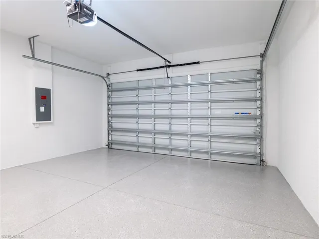 Garage featuring electric panel and a garage door opener
