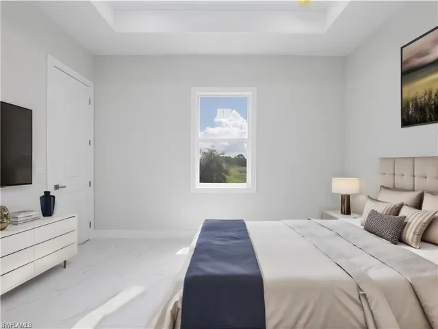 Bedroom with tile patterned floors and a raised ceiling