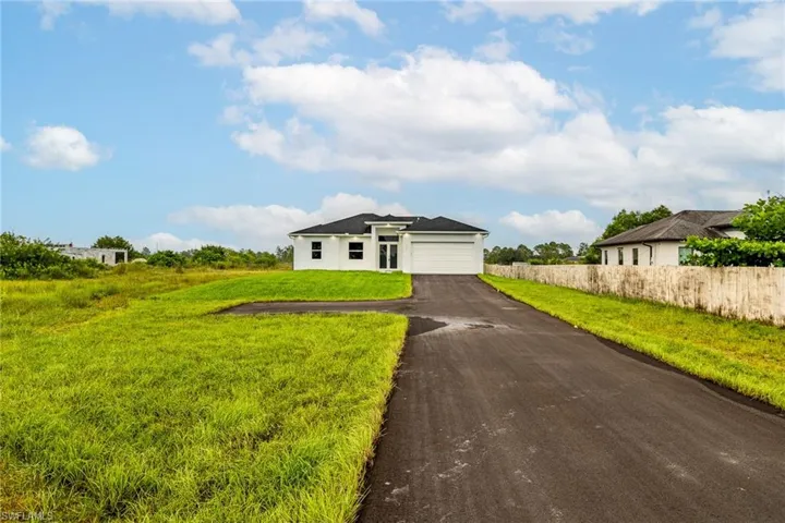 View of front facade featuring a front yard and a garage