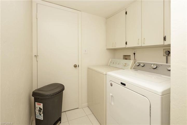 Separate laundryroom with extra storage cabinets/closet.