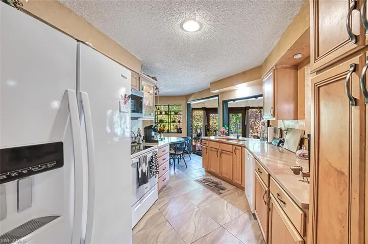 Kitchen featuring sink, appliances with stainless steel finishes, a textured ceiling, and light tile patterned floors