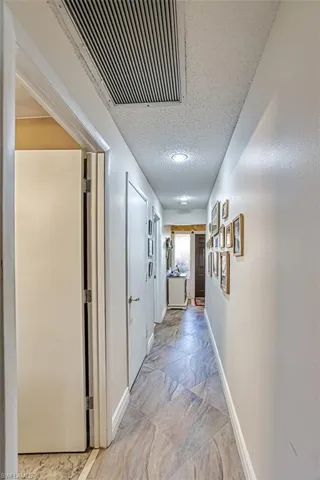 Hall with a textured ceiling