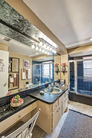 Bathroom featuring vanity, tile patterned floors, and an enclosed shower