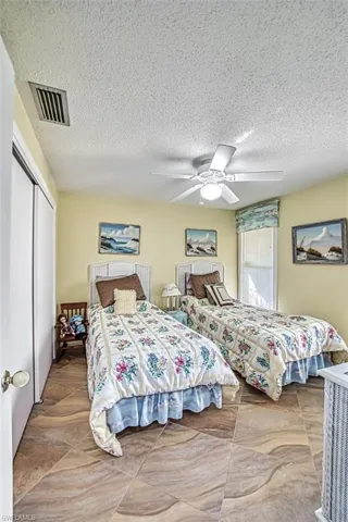 Bedroom featuring a textured ceiling, a closet, and ceiling fan