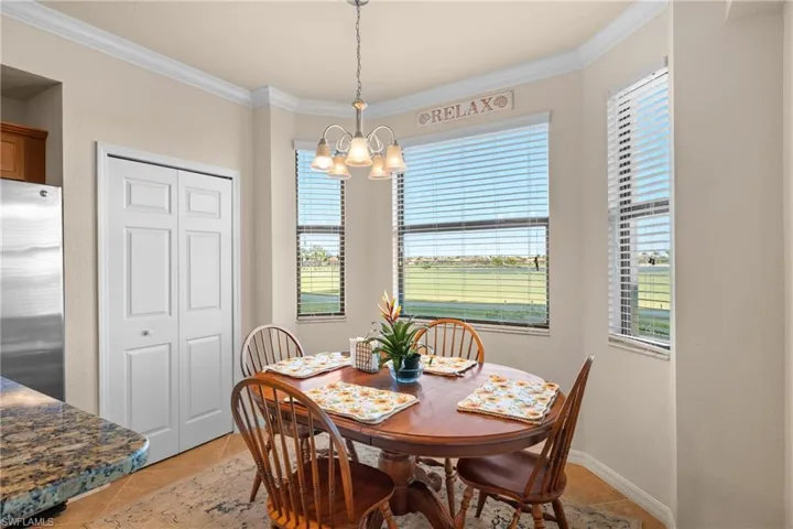 Dining room with a wealth of natural light, a notable chandelier, and crown molding
