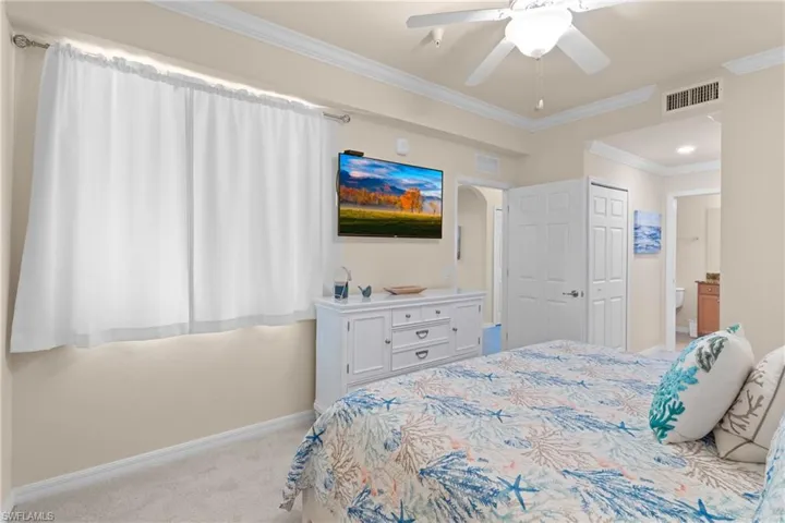 Bedroom with visible vents, baseboards, carpet, and ornamental molding