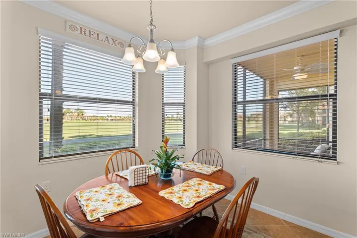 Tiled dining room featuring a notable chandelier, baseboards, and ornamental molding