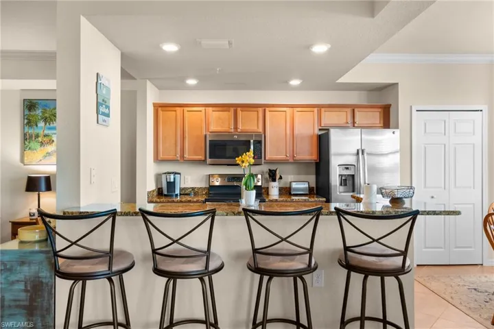 Kitchen featuring light tile patterned flooring, recessed lighting, stainless steel appliances, and ornamental molding