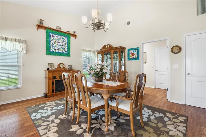 Dining space with high vaulted ceiling, dark hardwood / wood-style floors, and a notable chandelier