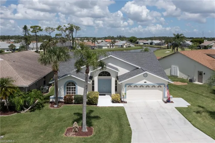 View of front of home featuring a garage, central AC unit, and a front yard