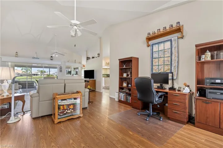 Office area featuring hardwood / wood-style flooring, high vaulted ceiling, and ceiling fan