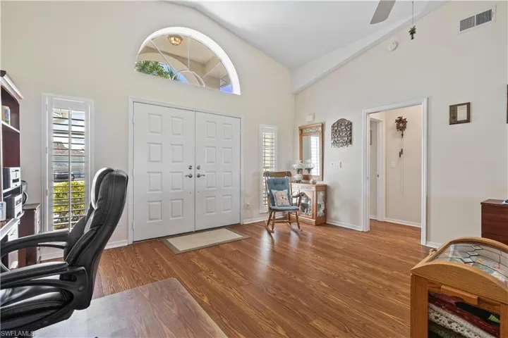 Office featuring ceiling fan, wood-type flooring, and high vaulted ceiling