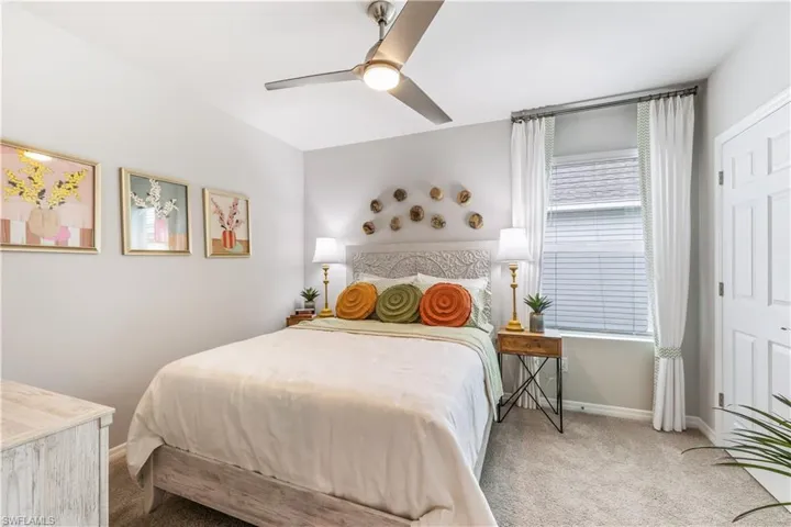 Carpeted bedroom featuring ceiling fan