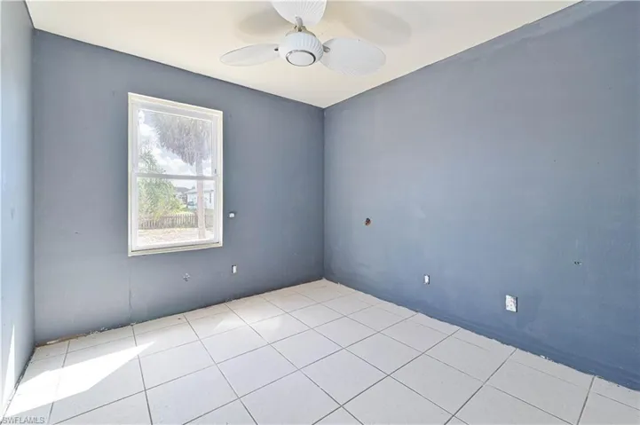 Unfurnished room with ceiling fan and light tile patterned floors
