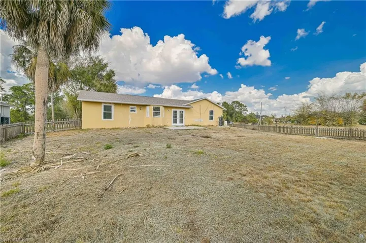 Back of house with a fenced backyard, french doors, stucco siding, and a patio