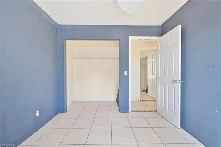 Unfurnished bedroom featuring light tile patterned floors and a closet