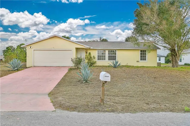 Ranch-style house featuring stucco siding, a garage, and driveway
