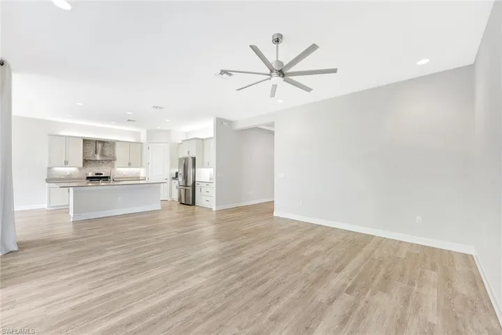 Unfurnished living room with ceiling fan and light wood-type flooring