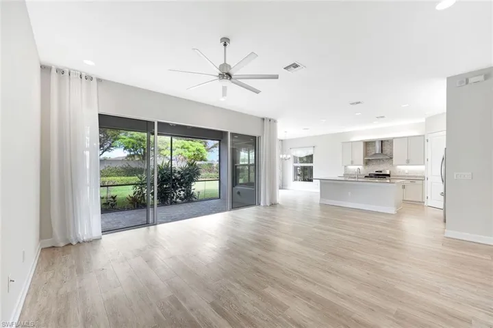 Unfurnished living room with ceiling fan, sink, and light hardwood / wood-style flooring