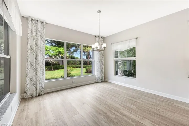 Unfurnished room with a notable chandelier and light hardwood / wood-style floors