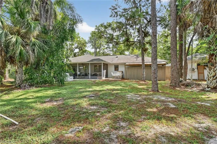 Back of house featuring a sunroom, a lawn, and a patio area