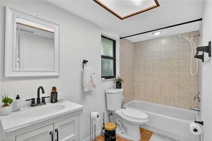 Full bath featuring bathing tub / shower combination, vanity, and light tile patterned floors