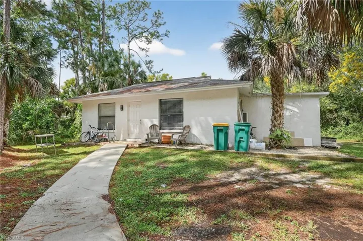 Back of property with stucco siding and a lawn
