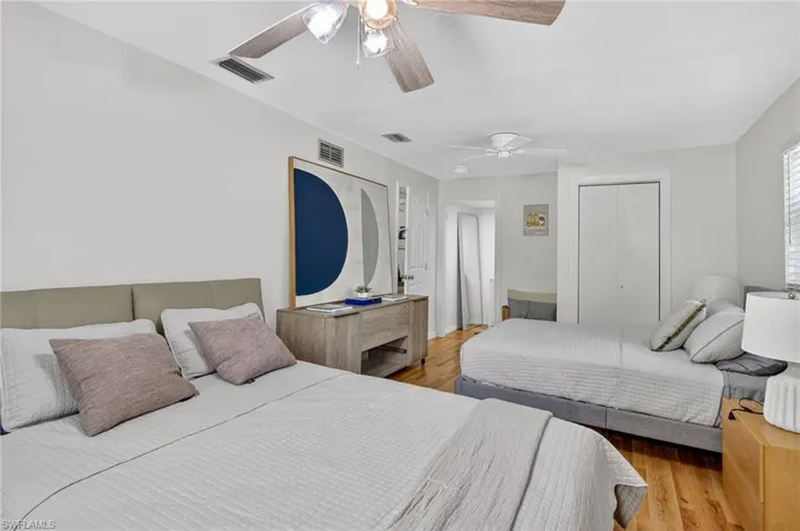 Bedroom with a closet, wood finished floors, and a ceiling fan