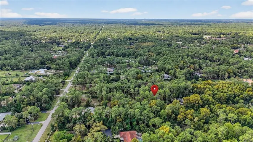 View of property location featuring a forest