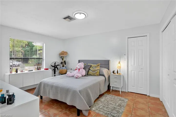 Bedroom featuring light tile patterned floors and a closet
